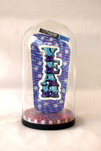 Sculpture of an acrylic shape in a glass dome with a 60s computer style sign on the top and the words 'YEAH' and 'NAH' on each side