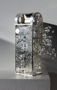an aluminium sculpture of a mailbox completely made from tags, stickers and signage